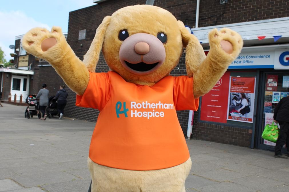 A large mascot dog wearing an orange t-shirt 