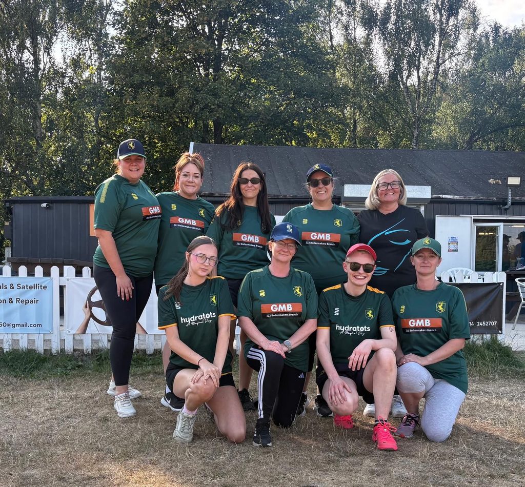 A group of female cricket players stood for a photo