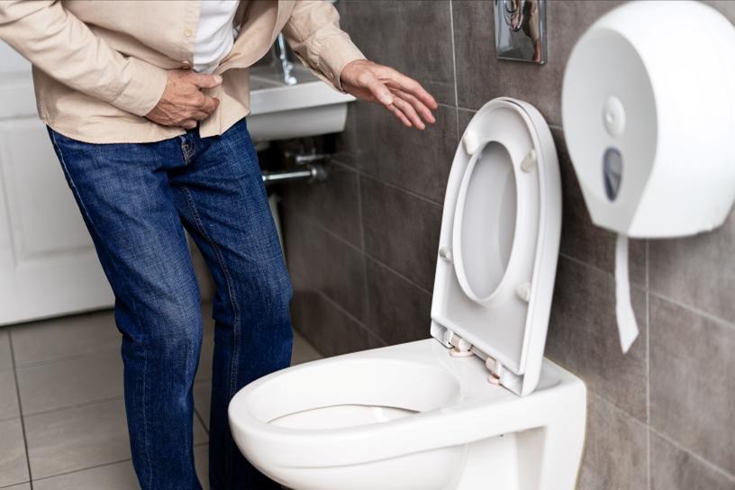 A man rushing to use the toilet